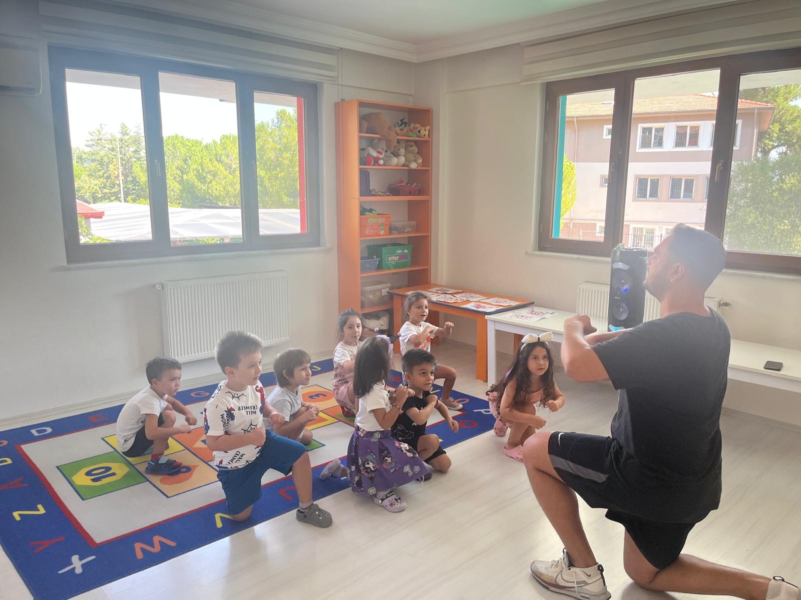 Özgün Çocuklar'da dans dersinde müzik eşliğinde hareket eden çocuklar